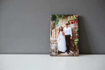 Canvas print wedding photography on white table and grey wall background