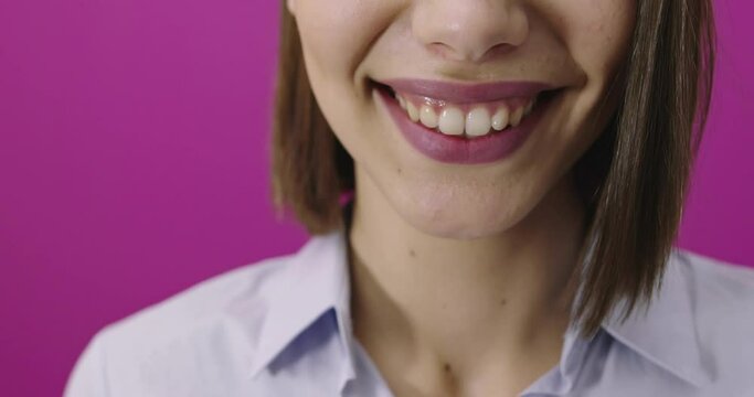 Positive woman smiling over pink backgorund