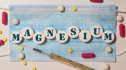 Organic pumpkin seeds with the word magnesium on small wooden dices