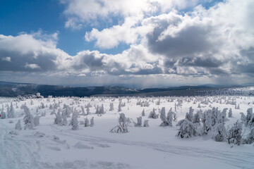 Winter mountain landscape, Poland, Panorama of the Giant Mountains in sunny winter day, from Biała Dolina in Szklarska Poreba on Szrenica and Sniezne Kotly, blue sky, white and dark clouds. Snow cover