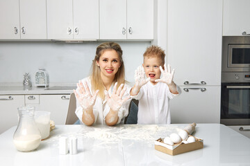 Obraz na płótnie Canvas Mom and child cook in a white kitchen made of dough