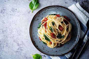 Pasta with dried tomatoes and spinach in a plate