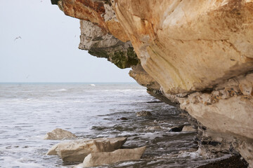 Small waves rolling under the limestone cliff at Bulbjerg in Denmark