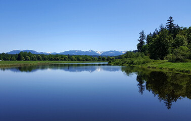 View of the Snoqualmie River and the Cascade mountain range during a peaceful sunny day.