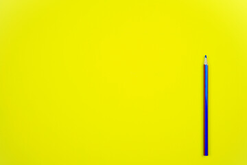 Toma en primer plano de un pósit amarillo teniendo a un lado un lápiz azul con los laterales rojos dispuesto para tomar cualquier nota oportuna a modo de recordatorio.