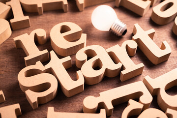 Restart business idea, Restart wood word with glowing light bulb