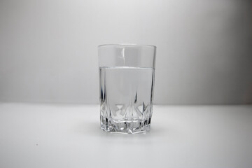 Close up of purified, filtered fresh drinking water from bottle on table, on white background