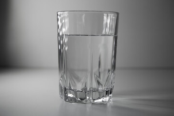 Close up of purified, filtered fresh drinking water from bottle on table, on white background