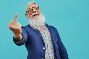 Older hipster man in positive attitude with happy facial expression shows fuck you. - Focus on the...