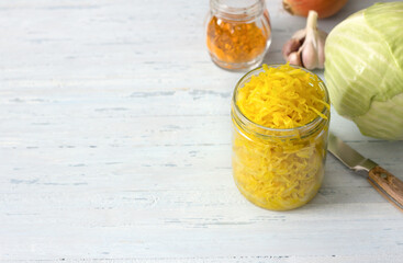 Homemade sauerkraut with garlic, onion and turmeric on a light blue background. healthy fermented food, natural probiotic, vegan food. top view, space