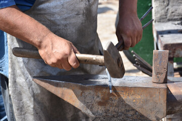 Blacksmith forged ironsmith. traditional hammer beating. Medieval blacksmith. Horseshoe workspace...