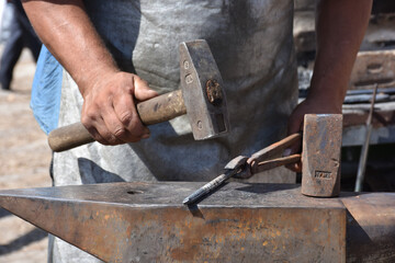 while blacksmith beating iron in old fashion