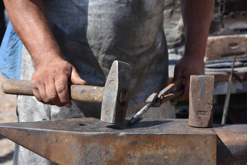 Blacksmith forged ironsmith. traditional hammer beating. Medieval blacksmith. Horseshoe workspace made with the medieval blacksmith method