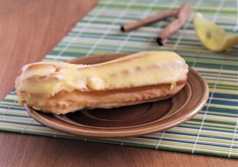 sweet eclair dessert with lemon cream and cinnamon on the green tablecloth