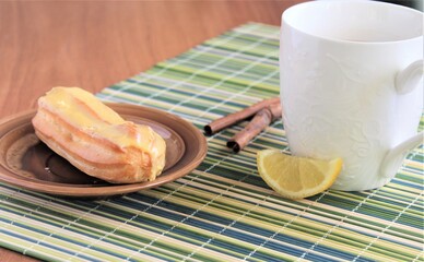 cup of coffee and tablecloth eclair dessert with lemon cream on the tablecloth