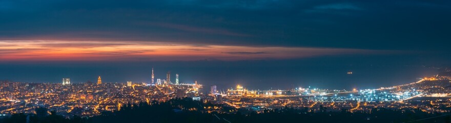 Fototapeta na wymiar Batumi, Adjara, Georgia. Panorama, Aerial View Of Urban Cityscape At Sunset. Town At Evening Blue Hour time. City And Port In Night Lights Illuminations