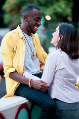 young multiethnic couple in love hugging and laughing,colorful clothes