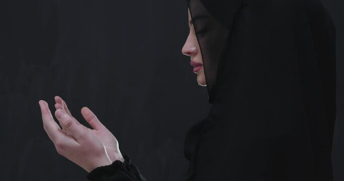 Portrait of beautiful muslim woman in fashionable dress with hijab making traditional prayer to God