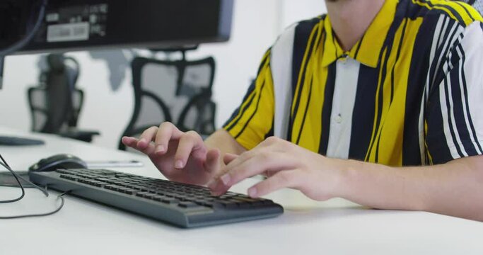 businessman working at his desktop computer sitting at his desk in the open space startup office