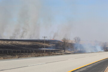 Pasture burning along Kansas turnpike with powerlines