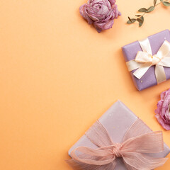 Gift boxes with dry flowers on orange background. flat lay, top view, copy space