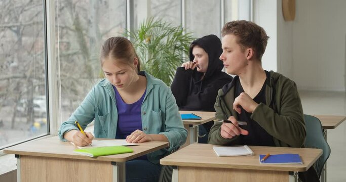 Teenage boy cheating during school test in classroom