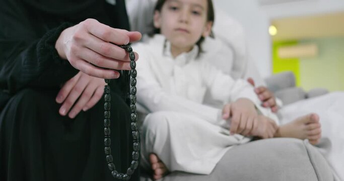 Muslim woman praying at home with kid in background