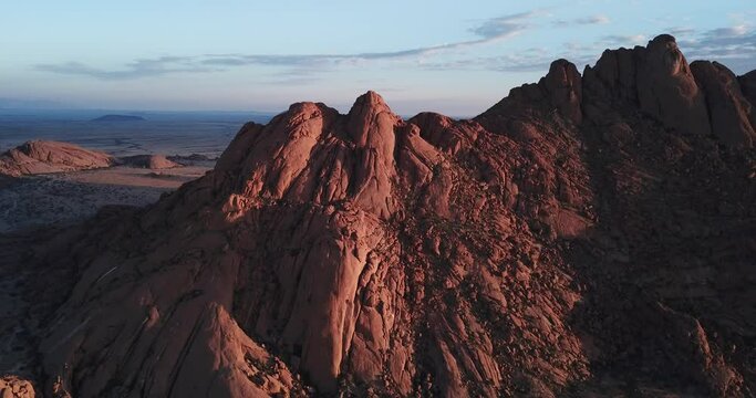 4K sunrise aerial footage of savanna, famous red granite Spitzkoppe Peak and Pontok Mountains in central Namibia between interior town Usakos and Atlantic west coast, southern Africa