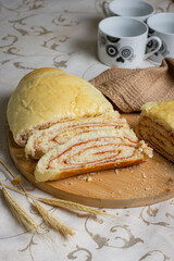 Vertical photo of slices of a partially cut bread on a cutting board.