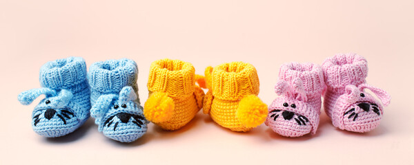 Set three Pairs of baby booties, shoes on pastel background, cozy conceptual idea. Guess gender of the child, baby shower party. Preparation and choice of color for newborn baby room