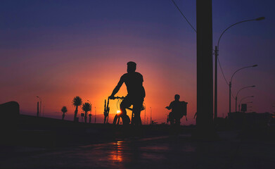 Fototapeta na wymiar Silhouette riding bicycle at sunset. Selective focus