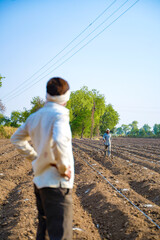 Indian farmer or labour Drip irrigation pipe assemble in agriculture field. rural scene.
