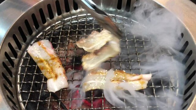 grilled meat on the grill A lot of smoke while grilling pork belly slice fire with high fat is carbon