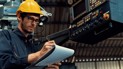 Skillful factory worker working with clipboard to do job procedure checklist . Factory production...
