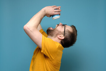Man is tormented by thirst, he threw back head, opened mouth and pours the last drops from a paper,...