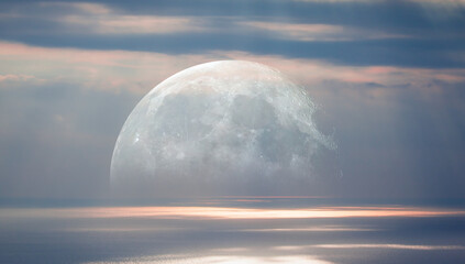Full moon rising above calm sea at sunset sky. 