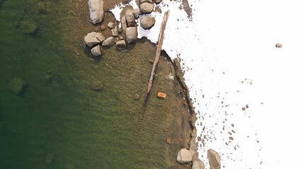 4K Aerial drone photo of snowy lake coastline 