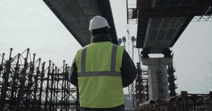 Unrecognizable engineer examining concrete bridge