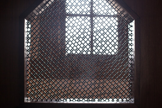 old priest inside the wooden confessional in a Christian church.