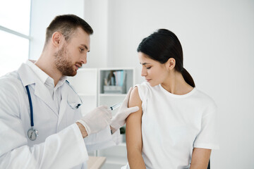 woman in hospital and doctor injecting coronavirus vaccine