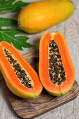 Fresh papaya cut in half on a wooden table