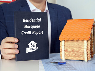 dark blue notepad in a hand with phrase Residential Mortgage Credit Report . Horizontal shot....