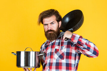 mature guy in checkered shirt with pan. stylish male going to cook food. bearded man with moustache...