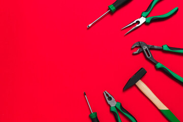 A set of quality green building tools to repair a car or a house on a red background. Do it yourself instruments. Banner for advertising construction shop with copy space. Business card.