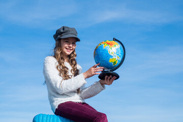 happy kid in cap search place for travel on geography globe map outdoor, location