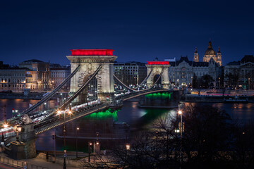 Budapest, Hungary - The world famous illuminated Szechenyi Chain Bridge (Lanchid) by night, lit up with national red, white and green colors, celebrating the 15th of March 1848 civic revolution day