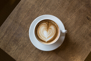 Cappuccino or latte coffee with heart shape in cafe.