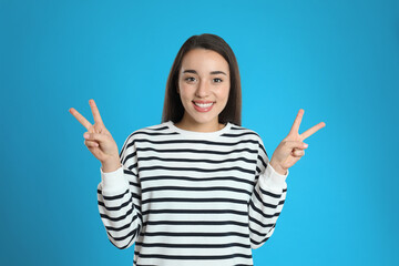 Woman showing number four with her hands on light blue background