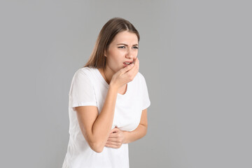 Fototapeta premium Woman suffering from nausea on grey background, space for text. Food poisoning