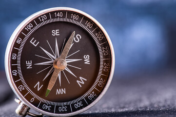 Travel planning navigation concept. Classic magnetic detail of  black compass on light blue backround